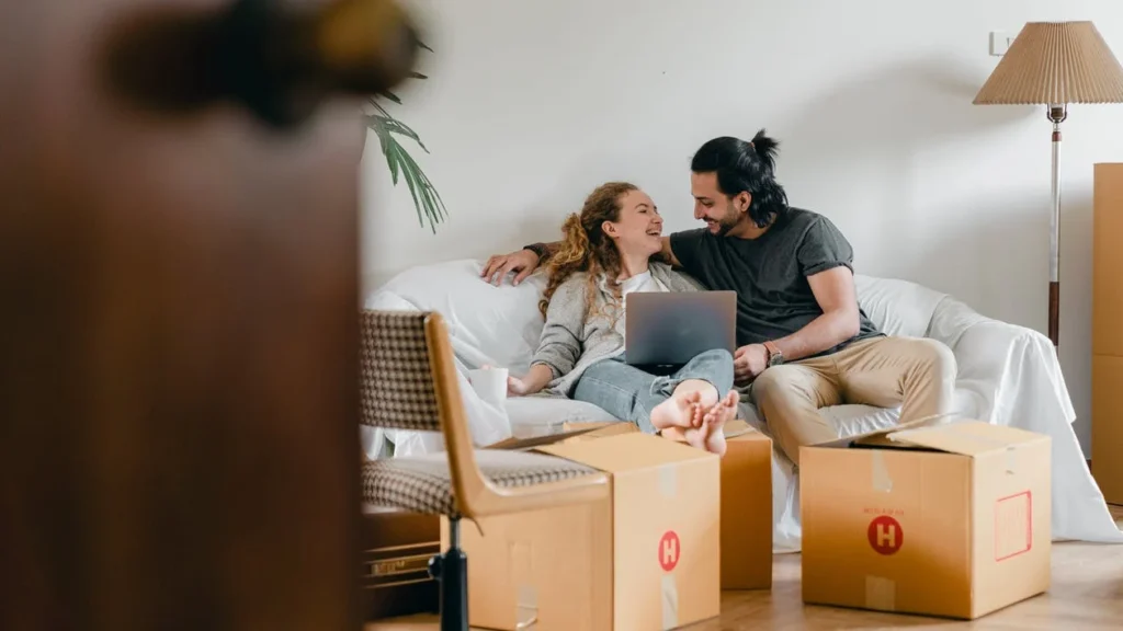 A couple sitting on the sofa and laughing together