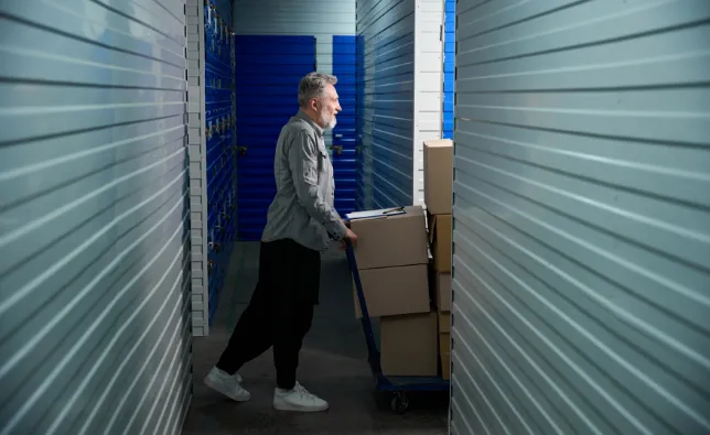 Man moving boxes into a storage unit